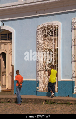 La vie quotidienne à Cuba - deux hommes marchant dans la rue pavée à Trinidad, Cuba, Antilles, Caraïbes, Amérique centrale en mars Banque D'Images