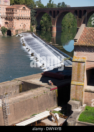 Une femme de soleil à côté d'un barrage sur la rivière Tarn à Albi, Languedoc, France, vue depuis le Pont Vieux Banque D'Images