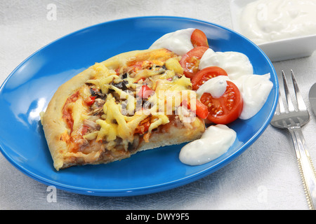Morceau de pizza maison au thon, poivrons, tomates et une sauce à l'ail Banque D'Images