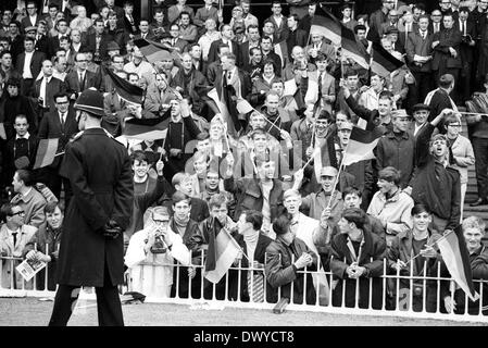 30.07.1966. Le stade de Wembley, Londres, en Angleterre. Finale de la Coupe du Monde 1966 l'Angleterre contre l'Allemagne (4-2) après prolongation. Des fans allemands à pleine voix suivie de près par un policier anglais Banque D'Images