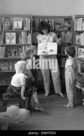 Berlin, RDA, bibliothécaire montre un groupe d'enfants d'âge préscolaire un livre Banque D'Images