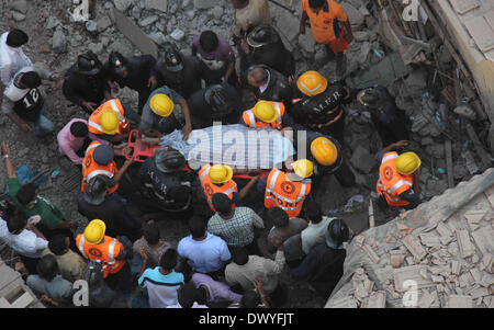 Mumbai, Inde. 14Th Mar, 2014. Les sauveteurs portent le corps d'une victime de l'incendie d'un immeuble à Mumbai, Inde, le 14 mars 2014. Au moins six personnes ont été tuées et plusieurs autres blessés lorsqu'un édifice de sept étages s'est effondré à Santa Cruz, dans la banlieue ouest de Mumbai vendredi matin, a dit la police indienne. Credit : Stringer/Xinhua/Alamy Live News Banque D'Images