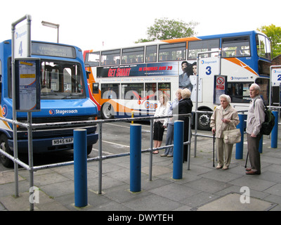 Les gens y compris les personnes âgées homme & femme avec des cannes d'attente et l'attente à la gare routière de Chichester Chichester West Sussex UK Banque D'Images