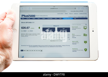Personne ayant un iPad tablet à sur Plus500 citant site Bitcoin cryptocurrency trading taux de change les prix en EUR pour cryptocurrencies Banque D'Images