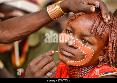 Hamer woman getting son visage peint lors d'une cérémonie près de Turmi bull sautant dans la vallée de l'Omo, Ethiopie Banque D'Images