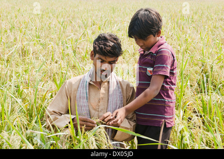Indian Farmer Standing in Farm avec kid Banque D'Images