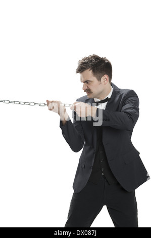 Homme dans un costume d'affaires tire sur une chaîne Banque D'Images
