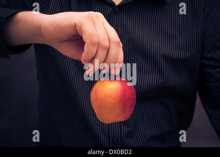 Un homme tenant une pomme rouge dans la main Banque D'Images