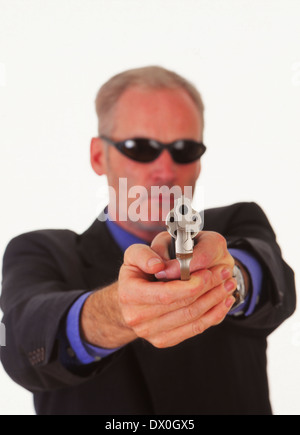 L'Homme à lunettes menace avec un pistolet, revolver Banque D'Images