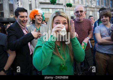 Londres, Royaume-Uni. Dimanche 16 mars 2014. Recueillir des fêtards dans le centre de Londres pour l'assemblée annuelle de la fête de la St Patrick. Saint Patrick ou fête de la Saint Patrick est une fête religieuse et culturelle célébrée chaque année le 17 mars, la date de décès de la plus couramment reconnu patron de l'Irlande, Saint Patrick. De nos jours la fête est un prétexte pour une ambiance et beaucoup d'alcool. Les gens invités à leur verre dans l'un. Crédit : Michael Kemp/Alamy Live News Banque D'Images