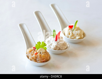 Assortiment de dips servi dans la porcelaine cuillères comme un finger food(dip à l'ail, aubergine, fromage feta dip) Banque D'Images