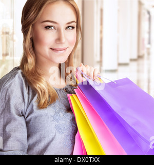 Closeup portrait of beautiful happy woman doing acheter dans le centre commercial, transportant des sacs de papier coloré Banque D'Images