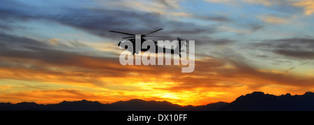 L'Armée américaine Un hélicoptère d'attaque AH-64 Apache, assigné à la Force sont tumultueuses revient à fonder au coucher du soleil après une mission dans la vallée de l'Uruzgan, 18 janvier 2013 à Tarin Kowt, Afghanistan. Banque D'Images