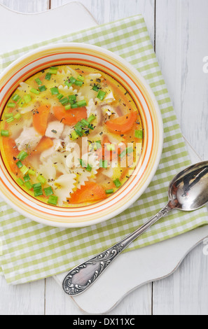 Soupe de poulet avec des pâtes farfalle dans le bol sur la table en bois Banque D'Images