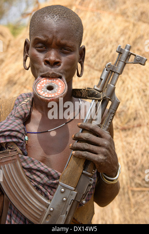 Femme Mursi avec la lèvre plate et dans la basse Kalachnikov Vallée de l'Omo d'Ethiopie. Banque D'Images