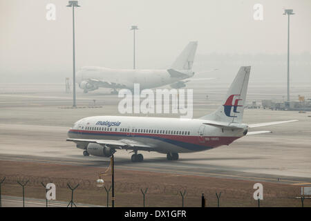 Un Boeing Co. 737 aéronefs exploités par Malaysian Airline System Bhd. (MAS) taxis à travers brume à l'Aéroport International de Kuala Lumpur (KLIA) à Sepang, Malaisie, le vendredi 14 mars, 2014. Banque D'Images