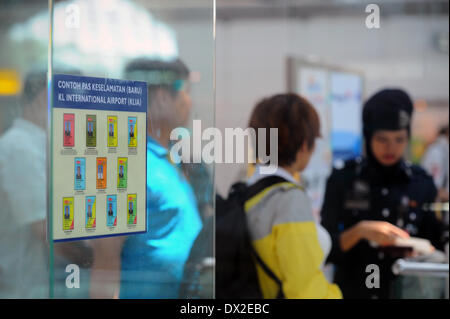 Kuala Lumpur, Malaisie. Mar 17, 2014. Les contrôles policiers et les passeports des voyageurs avant leur sélection comme il entre dans le neuvième jour de la disparition de la compagnie aérienne de la Malaisie, MH370 à l'Aéroport International de Kuala Lumpur à Sepang, à l'extérieur de Kuala Lumpur, Malaisie, le lundi 17 mars 2014. Credit : ZUMA Press, Inc./Alamy Live News Banque D'Images