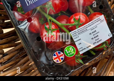 TOMATES CARTON ANGLAIS BRITANNIQUE 'Opie Jane' tomates de vigne dans l'emballage de supermarché avec motif Union Jack et autocollant de santé '1 sur 5 par jour' dans le panier Banque D'Images