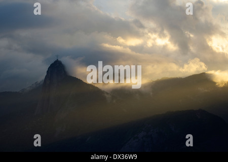 Statue du Christ Rédempteur apparaissant à travers les nuages au sommet de la montagne du Corcovado, Rio de Janeiro, Banque D'Images