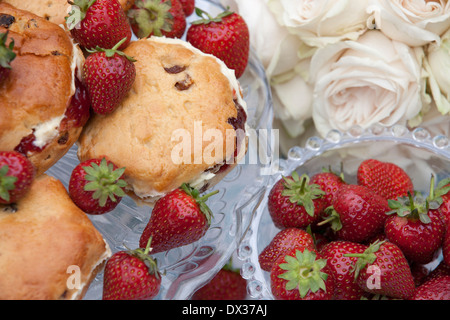 Des scones avec de la crème, de la confiture et des fraises sur un cake stand Banque D'Images