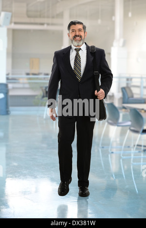 Hispanic businessman avec sac de balade à l'intérieur du bâtiment Banque D'Images