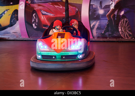 Petits enfants (garçon et fille) ont in electric autoscooter - bouclier dodgem voiture à fairground Banque D'Images