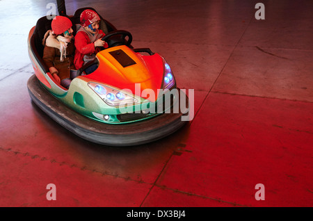 Petits enfants (garçon et fille) ont in electric autoscooter - bouclier dodgem voiture à fairground Banque D'Images