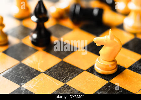 Échecs blanc et noir chiffres évêque debout sur échiquier Banque D'Images