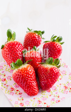 Gros plan du groupe de six fraises reposant sur serviette floral décoratif Banque D'Images