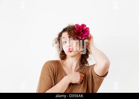 Jeune femme avec des lèvres rouge et une fleur dans les cheveux Banque D'Images