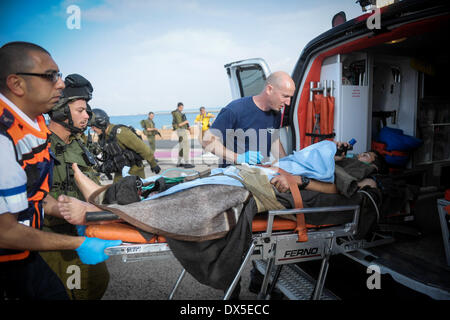 Jérusalem, Israël. 18 Mar, 2014. Un soldat israélien blessé est évacué d'un hélicoptère à une ambulance à l'hôpital Rambam à Haïfa dans le nord d'Israël, le 18 mars 2014. Un engin explosif a frappé un véhicule militaire israélien, mardi, dans les hauteurs du Golan près de la frontière nord avec la Syrie, a déclaré une source militaire. Les trois soldats israéliens blessés ont été évacués par un hélicoptère à l'hôpital de Haïfa au nord-ouest d'Israël, selon les médias locaux. Les Forces de défense israéliennes (FDI) ont déclaré qu'ils sont à la recherche dans les détails de l'incident. JINI ©/Xinhua/Alamy Live News Banque D'Images