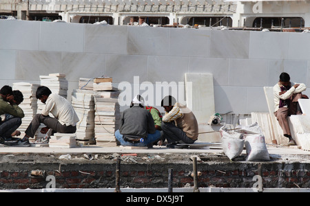 Travailler pour faire du carrelage en marbre à l'intérieur du site de construction le Temple d'or à Amritsar, en leur donnant la forme requise Banque D'Images