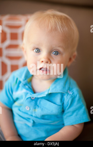 Wide-eyed baby garçon aux cheveux blonds et aux yeux bleus, portrait, Close up Banque D'Images