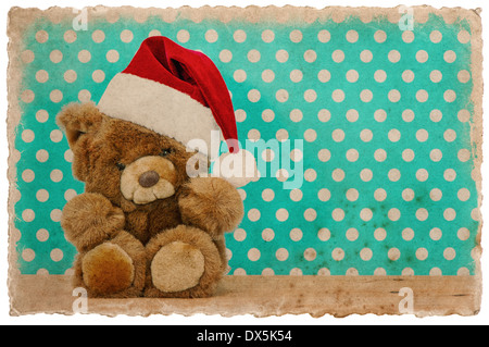 Cute vintage teddy bear with santa hat. Décoration de Noël carte postale photo style rétro. Banque D'Images