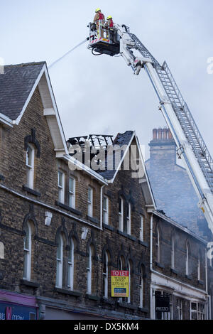 Pompier courageux équipage (2 pompiers) haut de bain, lutter contre le feu avec le tuyau d'eau au centre ville immeuble - Harrogate, North Yorkshire, Angleterre, Royaume-Uni. Banque D'Images