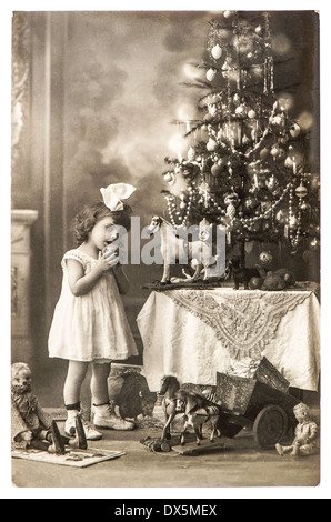 BERLIN, ALLEMAGNE - circa 1900 : antique photo de littele girl with christmas tree and vintage toys, vers 1900 à Berlin, Allemagne Banque D'Images