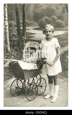 BERLIN, ALLEMAGNE - circa 1930 : Ancienne photo de petite fille à la poupée jouet vintage nostalgique. photo de ca. En 1930, Berlin Banque D'Images