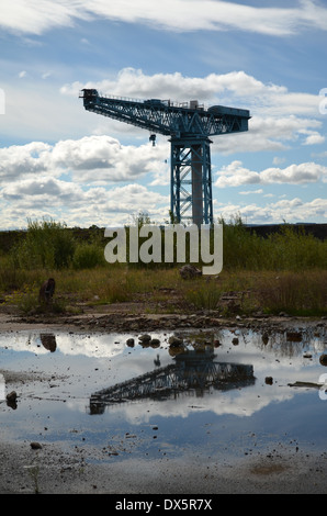 La grue Titan, reflétée dans l'eau de pluie sur ce qui était autrefois le site du célèbre John Brown's Shipyard Banque D'Images