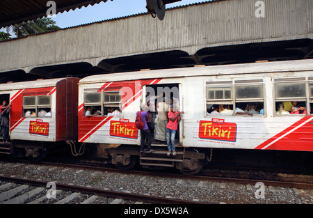 Gens en suspens aux portes ouvertes de commuter train passant par la gare de Mount Lavinia à Colombo Banque D'Images