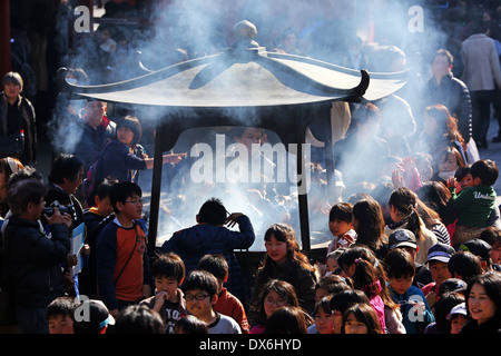 Des foules de gens de l'encens au Temple Shinto au Temple Bouddhiste Senso-Ji à Asakusa, Tokyo, Japan Banque D'Images