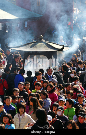 Des foules de gens de l'encens au Temple Shinto au Temple Bouddhiste Senso-Ji à Asakusa, Tokyo, Japan Banque D'Images