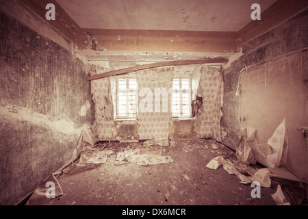 Chambre vide ruineuse avec de vieux papiers peints et filtre couleur sépia. Banque D'Images