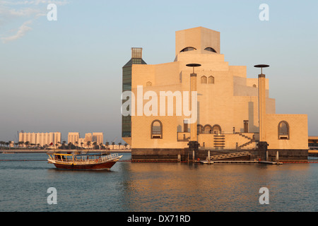 Un bateau en bois traditionnel voiles passé le musée d'Art islamique de Doha, au Qatar. Banque D'Images