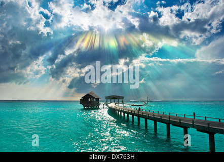 Magnifique coucher de soleil sur la mer. Maison de vacances avec fond ciel dramatique et rayons Banque D'Images