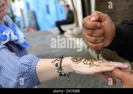 Une femme obtient un tatouage au henné sur la main au Maroc Banque D'Images