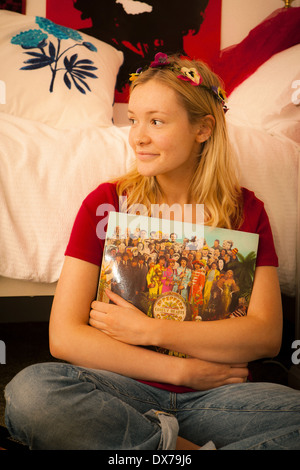 Jolie adolescente dans sa chambre, profitant de sa collection de disques Banque D'Images