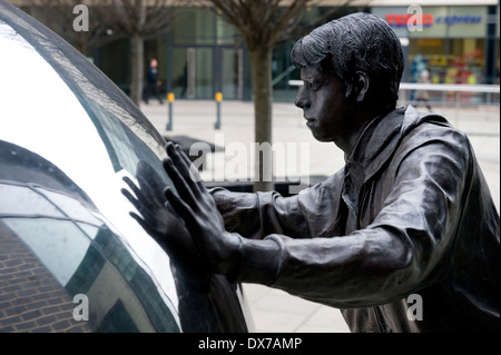 Sculpture dans le nouveau dock, anciennement Clarence Dock, Leeds, montrant la figure de bronze grandeur nature poussant bille en acier inoxydable. Banque D'Images