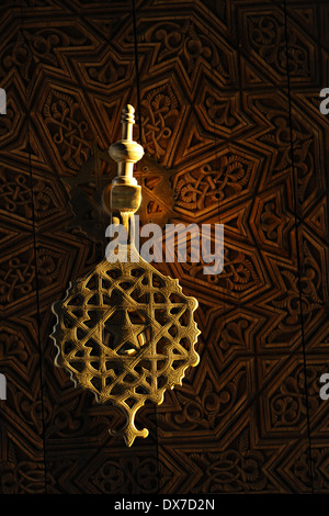 De couleur or style marocain heurtoir sur une porte en bois finement sculptés. Banque D'Images