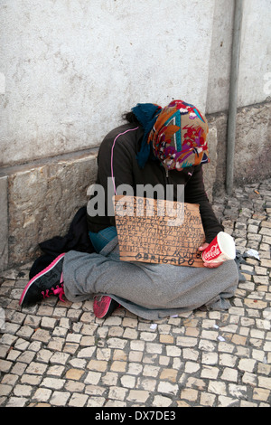 Une femme mendiant avec un panneau de message à Lisbonne, Lisboa, Portugal. Banque D'Images