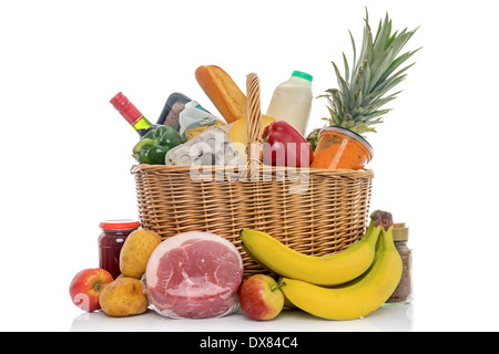 Panier en osier plein d'épicerie comprenant des fruits, légumes, viandes et produits laitiers. Banque D'Images